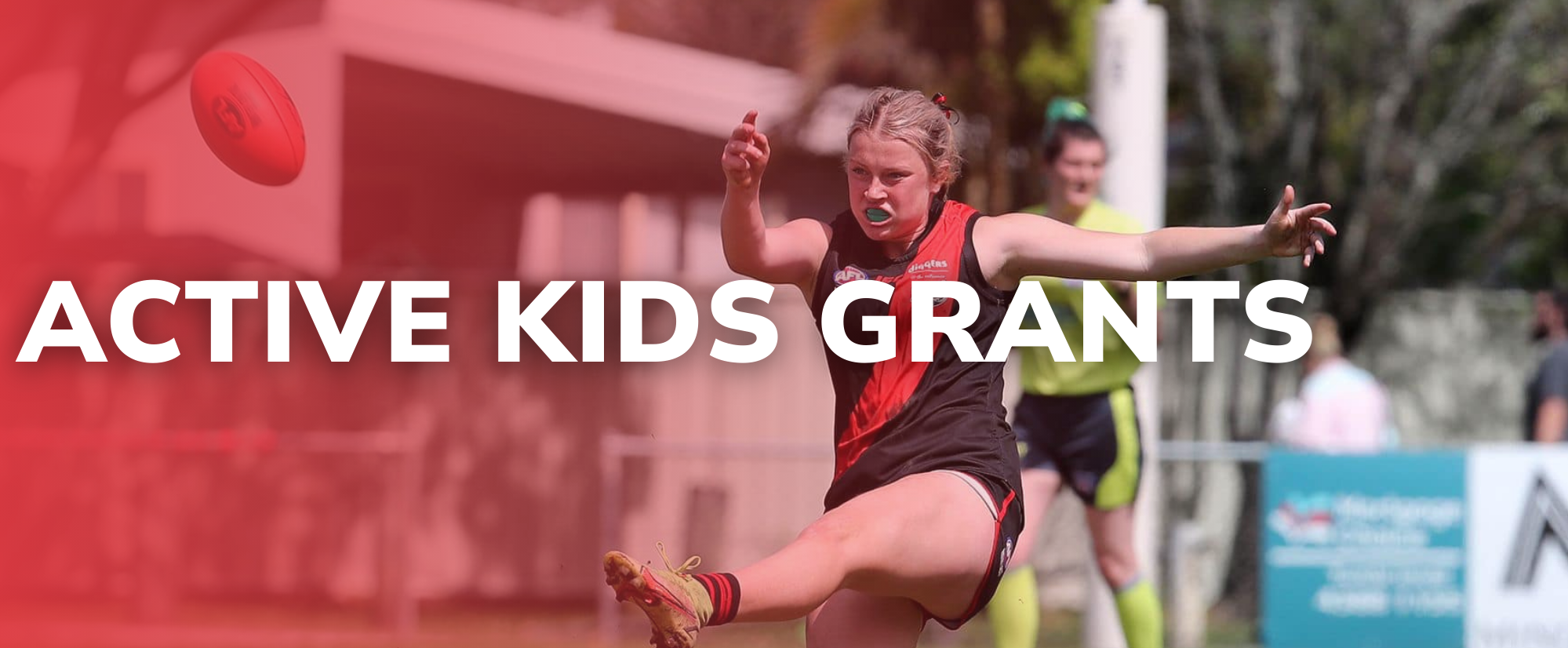 Active Kids Grants young AFL player kicking a ball